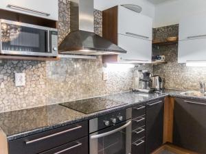 eine Küche mit Küchengeräten aus Edelstahl und einer Mikrowelle in der Unterkunft Holiday Home Vuokatinlampi 7 c by Interhome in Lahdenperä