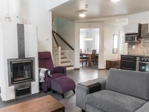 ein Wohnzimmer mit Couch und Kamin in der Unterkunft Holiday Home Vuokatinlampi 7 c by Interhome in Lahdenperä + 18 Fotos