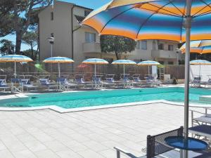 - une piscine avec des chaises et des parasols à côté d'un bâtiment dans l'établissement Apartment Riviera 10 by Interhome, à Marina di Cecina 25 autres photos