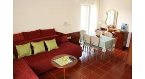 察夫塔特的住宿－Guest House Sol，客厅配有红色的沙发和桌子