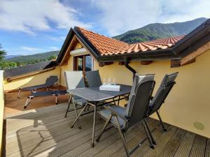 patio ze stołem i krzesłami na tarasie w obiekcie Apartment Torre del Lago by Interhome w mieście Porto Valtravaglia