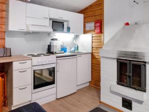 Il comprend une cuisine équipée d'appareils électroménagers blancs et d'une cuisinière. dans l'établissement Holiday Home Puolukka by Interhome, à Herttua 11 autres photos