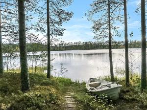 un bateau posé sur la rive d'un lac dans l'établissement Holiday Home Puolukka by Interhome, à Herttua