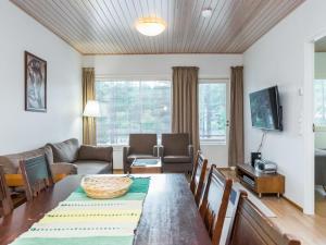 ein Wohnzimmer mit Tisch und Couch in der Unterkunft Holiday Home Elvi by Interhome in Lahdenperä