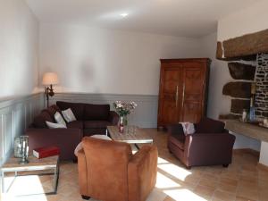 a living room with two couches and a table at Holiday Home La Tronçonnais by Interhome in Les Portes du Coglais +23 photos
