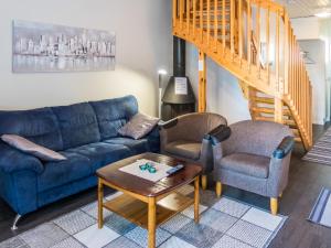 a living room with a blue couch and two chairs at Holiday Home Kisala by Interhome in Lahdenperä