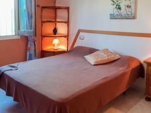 um quarto com uma cama com um cobertor castanho em Holiday Home Melina - MPL386 by Interhome em Miami Platja