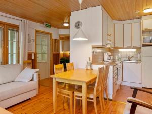 kuchnia i jadalnia z drewnianym stołem i krzesłami w obiekcie Holiday Home Sammal by Interhome w mieście Kukkola