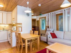 a kitchen and living room with a table and a couch at Holiday Home Vadelma by Interhome in Kukkola