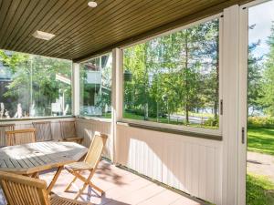 KukkolaにあるHoliday Home Vadelma by Interhomeの窓、テーブルと椅子が備わるスクリーンポーチ