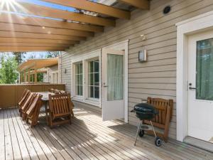 a wooden deck with a table and chairs on a house at Holiday Home 4 seasons hymy a by Interhome in Lahdenperä