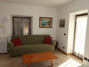 Tenna にあるApartment Casa Valentini by Interhomeのリビングルーム(緑のソファ、テーブル付)