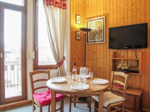 une salle à manger avec une table avec des chaises et une télévision dans l'établissement Apartment Le Carlton-7 by Interhome, à Chamonix-Mont-Blanc