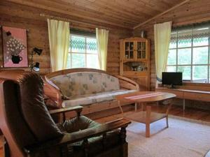 ein Wohnzimmer mit einem Sofa und einem Tisch in der Unterkunft Holiday Home Taukotupa by Interhome in Höytee