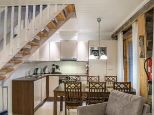 アカスロンポロにあるHoliday Home Sapara v- p61 by Interhomeのキッチン(白いキャビネット、テーブル、椅子付)