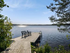 KosulaにあるHoliday Home Kärkiniemi by Interhomeの湖の桟橋に座る二つのベンチ