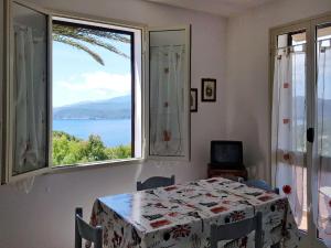 une salle à manger avec une table et une grande fenêtre dans l'établissement Apartment Palma by Interhome, à Capoliveri