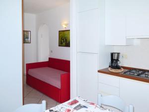 una piccola cucina con panca rossa e piano cottura di Apartment Palma by Interhome a Capoliveri Altre 11 foto