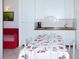 カポリーヴェリにあるApartment Palma by Interhomeのキッチン(テーブル、白いキャビネット付)