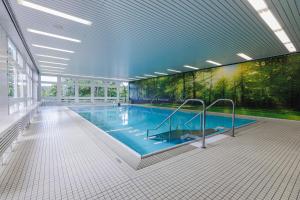 a large swimming pool in a large building at Hotel Kurhaus Bad Bocklet in Bad Bocklet