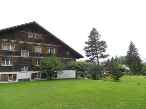 a large house with a large yard in front of it at Apartment Suzanne Nr- 27 by Interhome in Gstaad