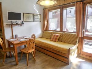 ein Wohnzimmer mit einem Sofa, einem Tisch und einem Fenster in der Unterkunft Apartment Les Jardins du Mont-Blanc-5 by Interhome in Chamonix-Mont-Blanc
