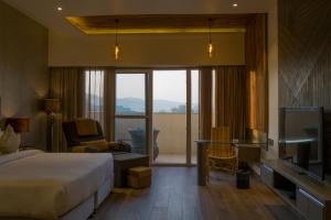 une chambre d'hôtel avec un lit et une télévision dans l'établissement Hotel Clarks Inn Suites Kangra, à Kangra