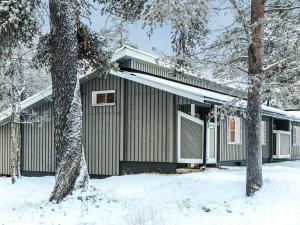 a house in the snow with trees in front of it at Holiday Home Riekonraito a1 by Interhome in Saariselka