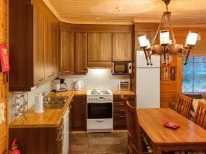 アカスロンポロにあるHoliday Home Lehtovilla a by Interhomeのキッチン(白い冷蔵庫、テーブル付)