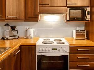 a kitchen with a white stove and a microwave at Holiday Home Lehtovilla a by Interhome in Äkäslompolo