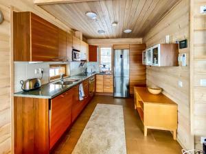 eine Küche mit Holzschränken und einem Edelstahlkühlschrank in der Unterkunft Holiday Home Alte ruka ansa by Interhome in Ruka