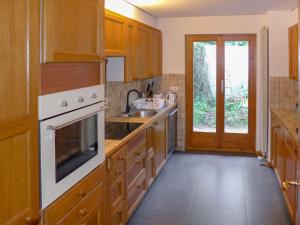 Una cocina con gabinetes de madera y un fregadero. en Chalet Chalet Aglaia by Interhome, en Bluche
