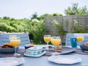 una mesa con vasos de zumo de naranja y comida en ella en Holiday Home Pont Neuf by Interhome, en Plouharnel