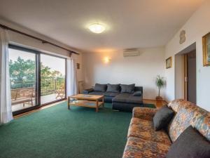 ein Wohnzimmer mit einem Sofa und einem Tisch in der Unterkunft Apartment Nives-2 by Interhome in Ičići