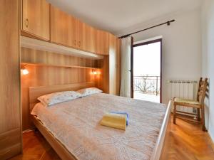 ein Schlafzimmer mit einem Bett mit einer gelben Tasche darauf in der Unterkunft Apartment Nives-2 by Interhome in Ičići