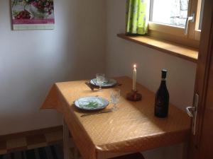 a table with a candle and a bottle of wine at Apartment Chalet Zimmermann by Interhome in Kiental