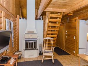 ein Wohnzimmer mit Kamin und Sessel in der Unterkunft Holiday Home Honkakoli 3 by Interhome in Hattusaari