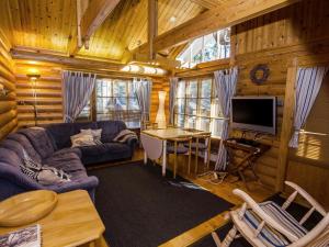 ein Wohnzimmer mit einem Sofa und einem TV in einer Hütte in der Unterkunft Holiday Home Honkakoli 3 by Interhome in Hattusaari