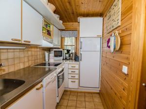 eine Küche mit weißen Geräten und Holzwänden in der Unterkunft Holiday Home Honkakoli 3 by Interhome in Hattusaari + 20 Fotos