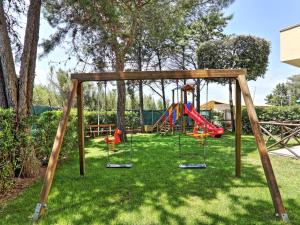 einen Spielplatz mit Schaukel im Hof in der Unterkunft Apartment Riviera 8 by Interhome in Marina di Cecina