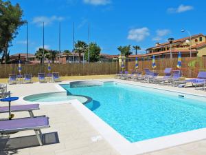 a swimming pool with lounge chairs and a resort at Apartment Riviera 8 by Interhome in Marina di Cecina
