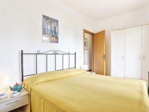 a bedroom with a bed with a yellow bedspread at Apartment Riviera 8 by Interhome in Marina di Cecina +20 photos