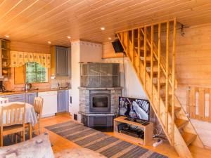 ein Wohnzimmer mit Treppe und Fernseher in einer Hütte in der Unterkunft Holiday Home Iltarusko by Interhome in Ruokonen