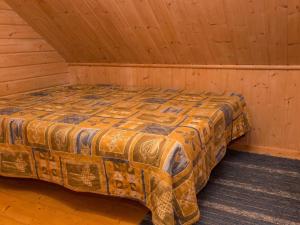 a bed in a room in a wooden cabin at Holiday Home Iltarusko by Interhome in Ruokonen