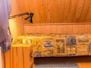 ein Schlafzimmer mit einem Bett in einer Holzwand in der Unterkunft Holiday Home Iltarusko by Interhome in Ruokonen