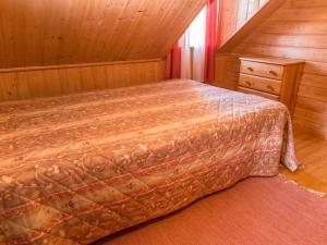 ein Schlafzimmer mit einem Bett in einem Holzzimmer in der Unterkunft Holiday Home Iltarusko by Interhome in Ruokonen + 14 Fotos