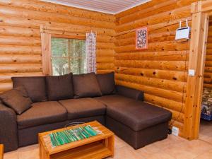 - un salon avec un canapé dans une cabane en rondins dans l'établissement Holiday Home Petra by Interhome, à Kolinkylä