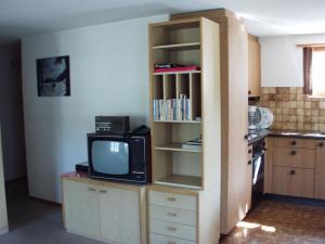 a kitchen with a tv and a book shelf at Apartment Teleboy by Interhome in Lenk