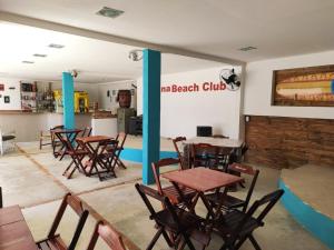 eine Gruppe von Tischen und Stühlen in einem Restaurant in der Unterkunft Pousada Laguna Beach Club in São Pedro da Aldeia