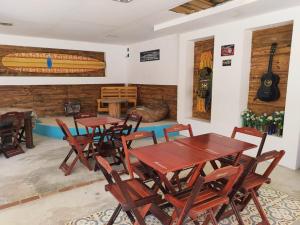 a room with wooden tables and chairs and a guitar at Pousada Laguna Beach Club in São Pedro da Aldeia